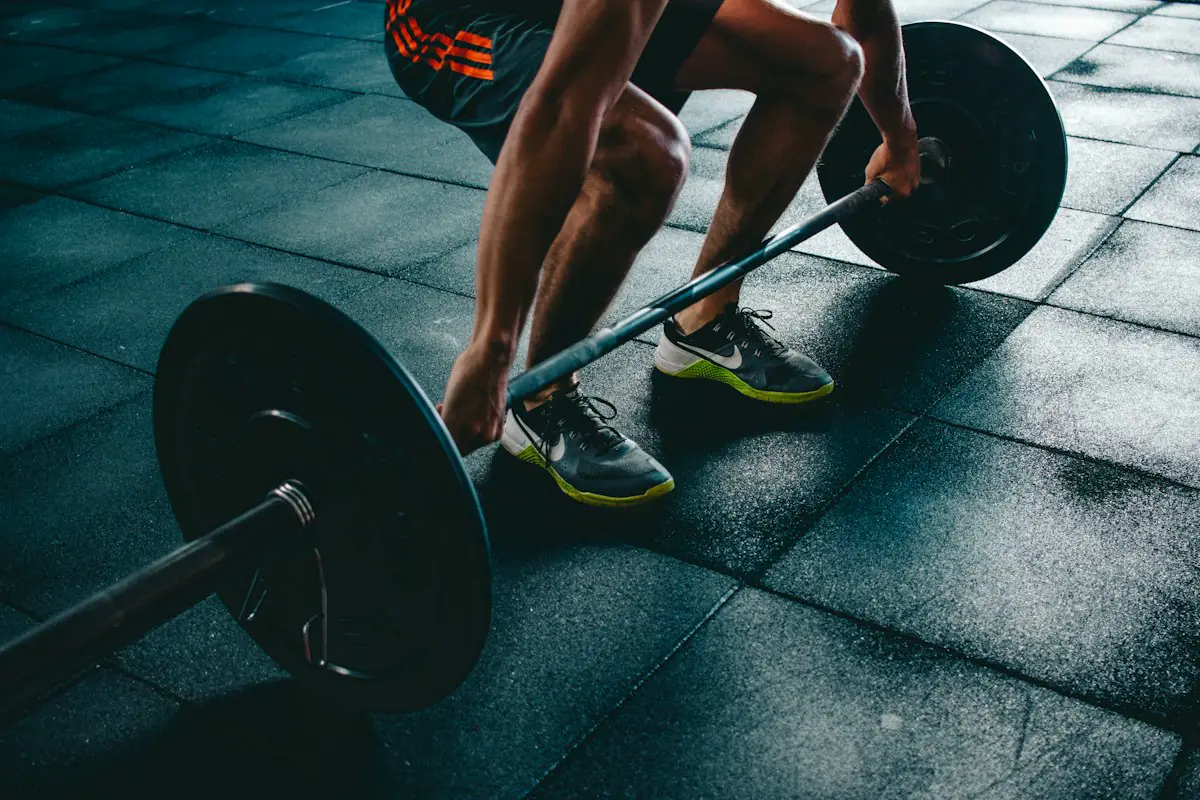 Athlete setting up to lift a loaded barbell from the gym floor