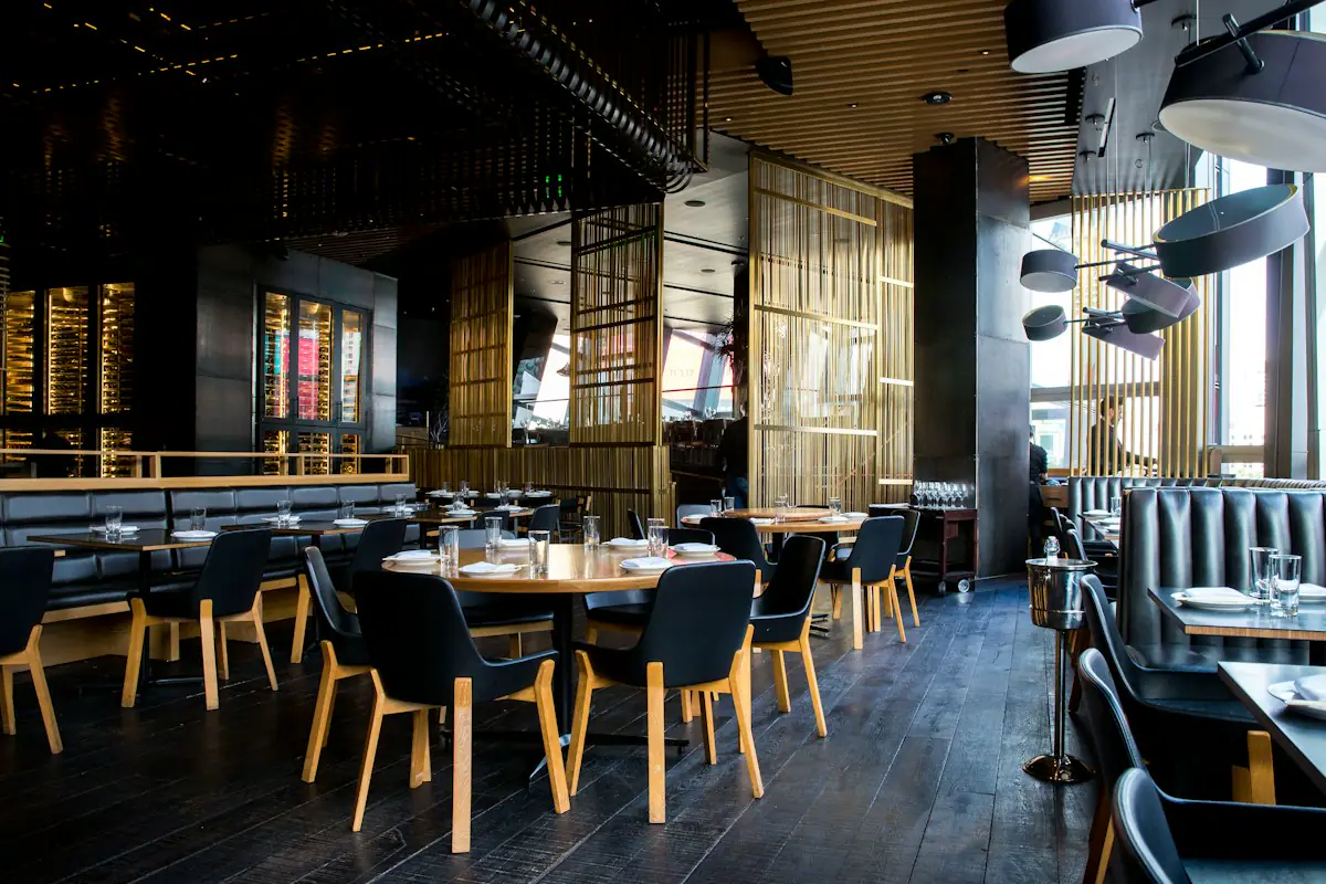 Modern restaurant interior with set tables and tall timber screens