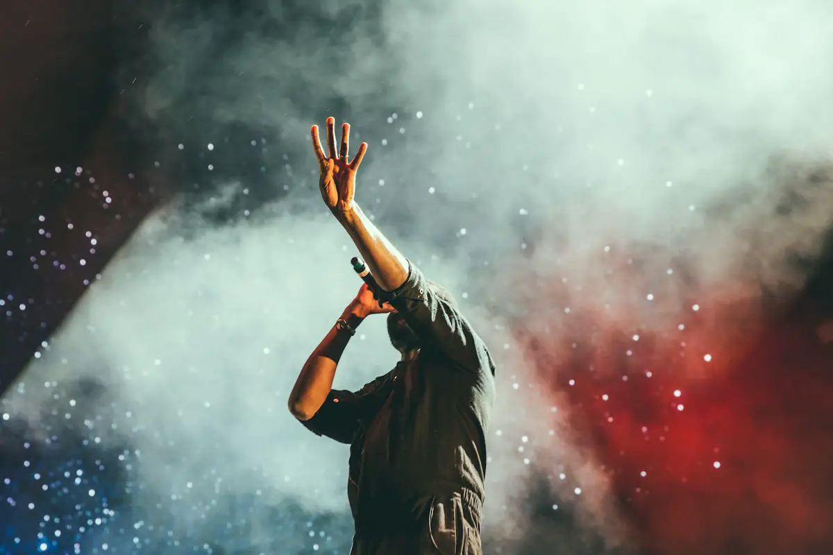 Singer performing into a microphone under smoky concert lights